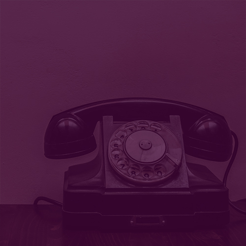 Retro rotary telephone on the table on wall background with copy space. Visiting card design.